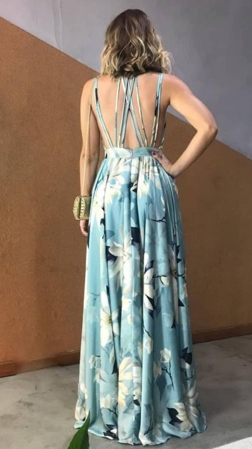 Vestido longo fluido azul claro com estampa floral, decote nas costas nuas e tiras cruzadas.