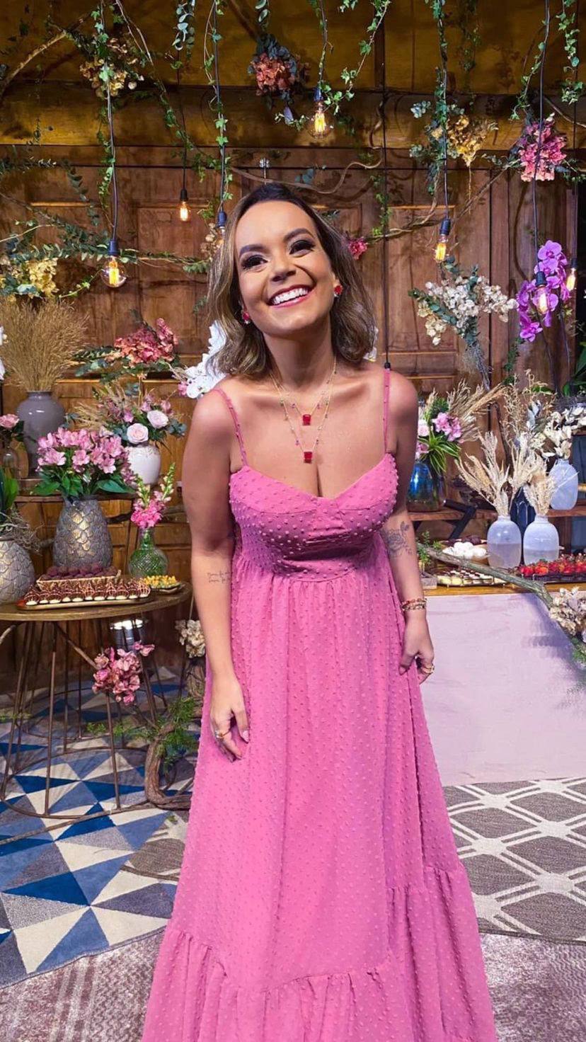 Vestido longo rosa com textura de poá, alças finas, decote estruturado e saia fluida com babado.