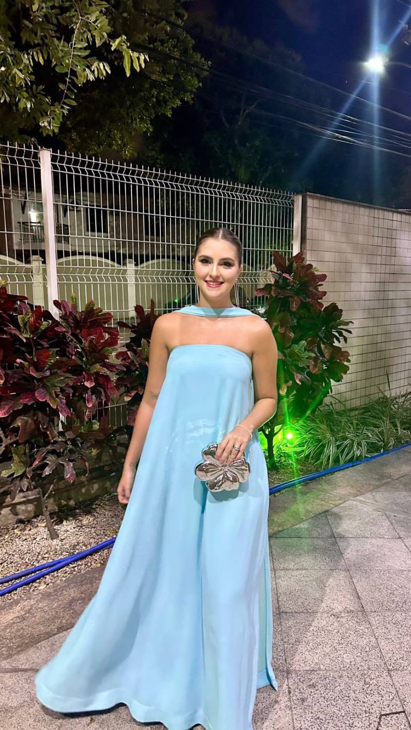 Vestido longo azul claro tomara que caia com caimento fluido, fenda na saia e faixa combinando no pescoço.