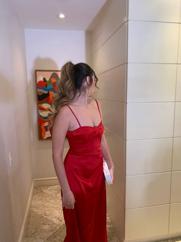 Vestido longo vermelho em cetim com alças finas, decote estruturado e caimento fluido.