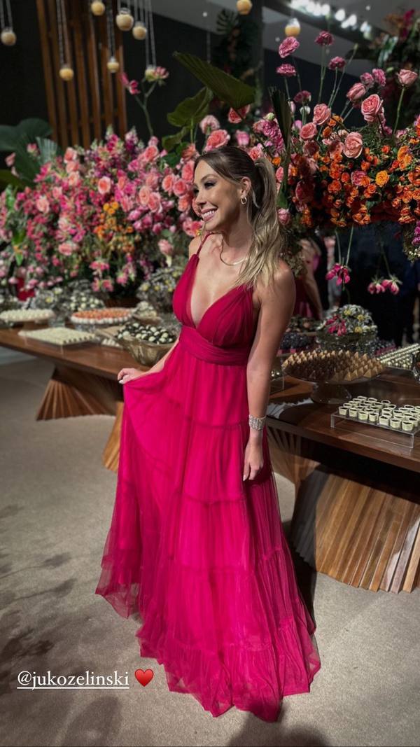 Vestido longo fúcsia de tule plissado, com alças finas, decote V e saia fluida em camadas.