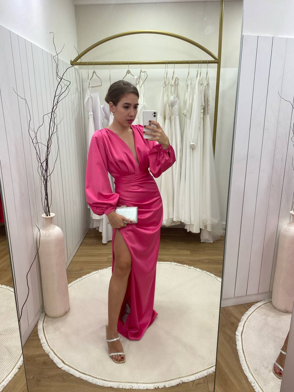 Vestido longo fúcsia em cetim, com mangas longas abuloadas, decote V e fenda frontal.