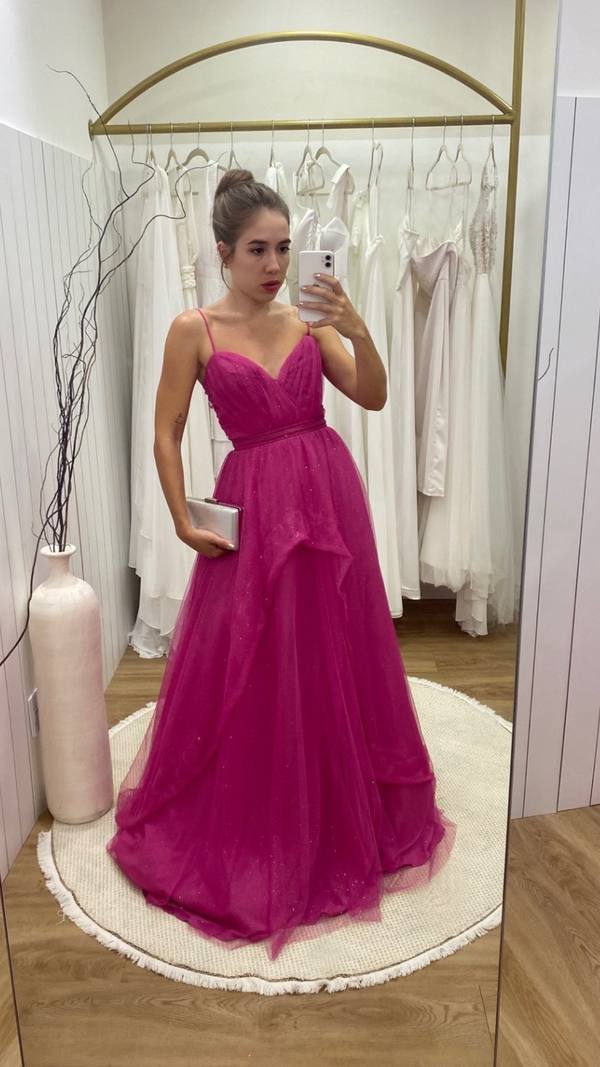 Vestido longo fúcsia em tule com brilho, alças finas, cintura marcada e saia volumosa estilo princesa.
