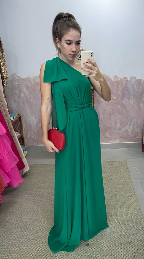 Vestido longo verde de um ombro só, em tecido fluido com detalhe de laço no ombro e amarração na cintura.