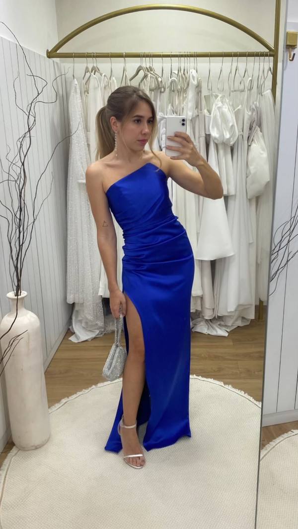 Vestido longo azul de cetim, decote tomara que caia com corte assimétrico, corpo drapeado e fenda alta na saia.