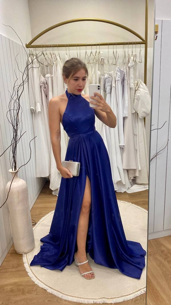 Vestido longo azul escuro em cetim, modelo frente única com cintura marcada, saia fluida e fenda.