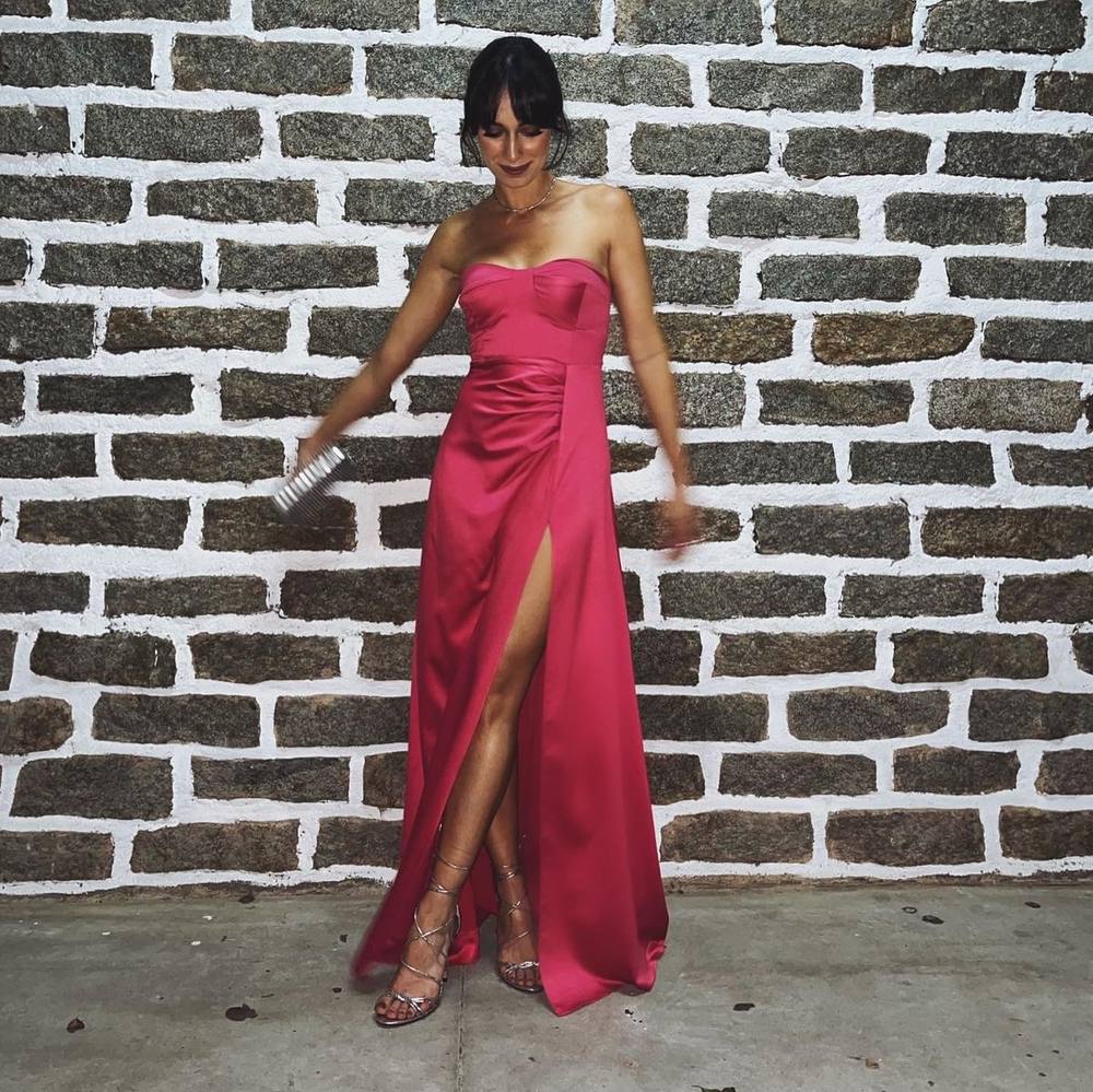 Vestido longo fúcsia tomara que caia em tecido acetinado, com fenda frontal e saia evasê.