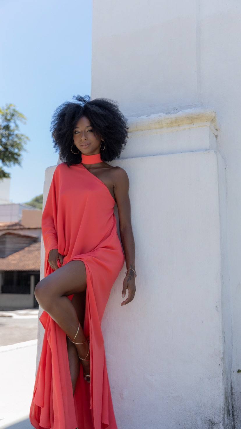 Vestido longo coral fluido de um ombro só, com detalhe no pescoço e fenda profunda na saia.