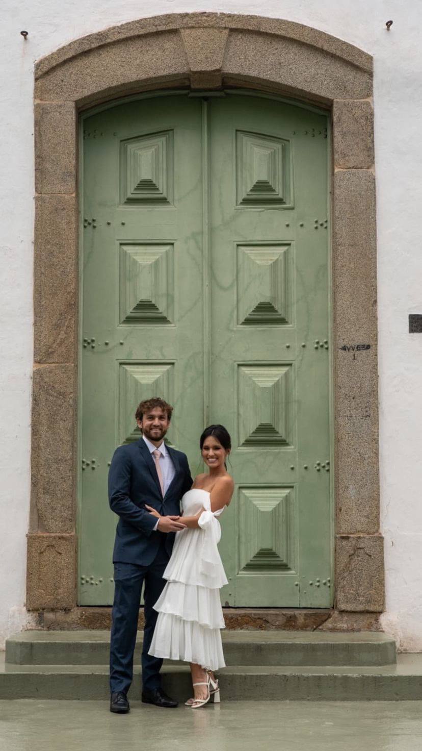 Vestido midi branco tomara que caia, com caimento fluido e saia em camadas de babados.