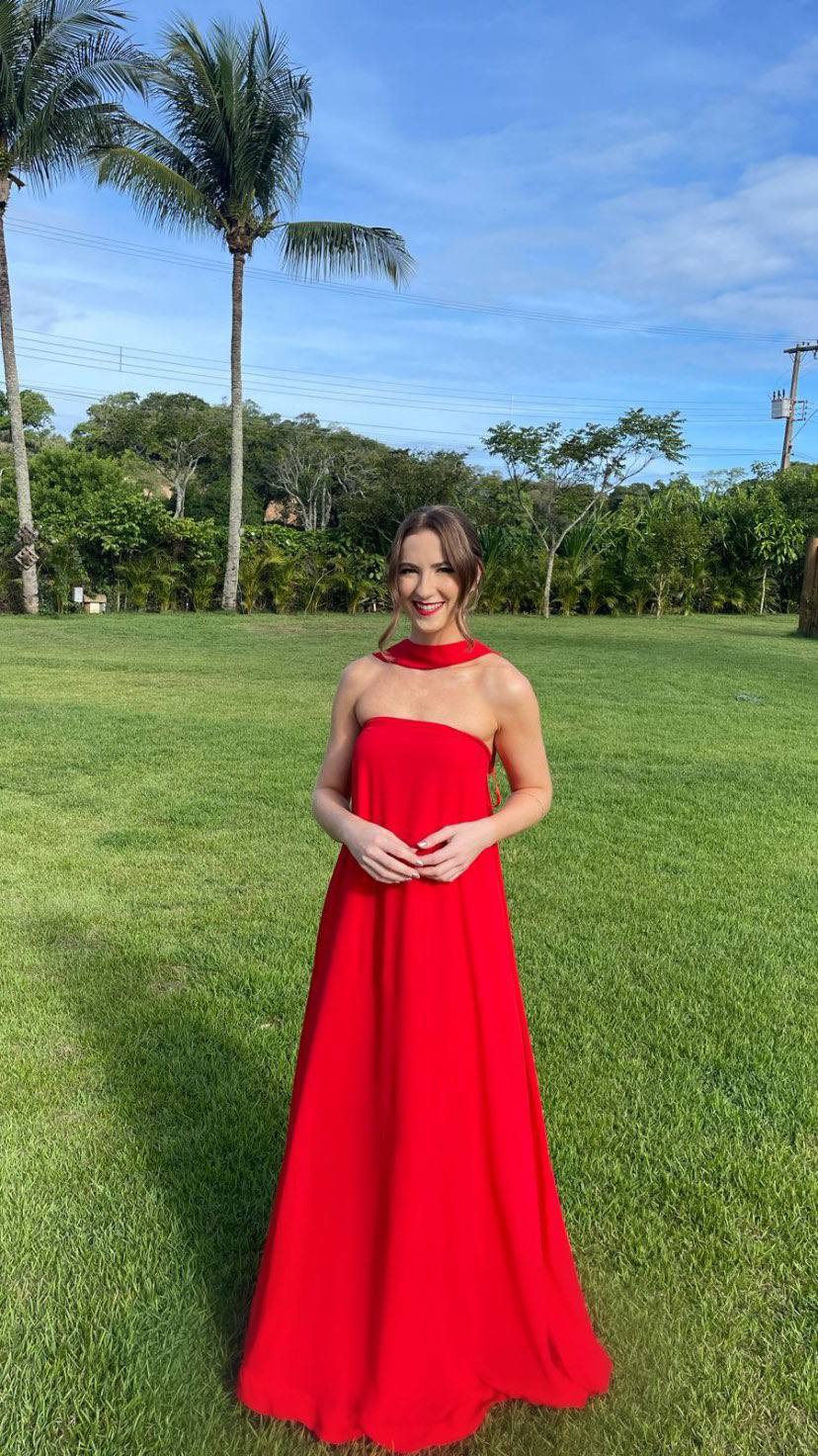 Vestido longo vermelho de caimento fluido, decote tomara que caia com detalhe de faixa no pescoço.