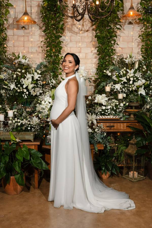 Vestido de noiva branco evasê com véu, em ensaio de gravidez