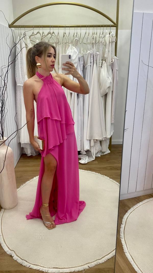 Vestido longo fúcsia fluido, com decote frente única, camadas sobrepostas no corpete e fenda lateral na saia.