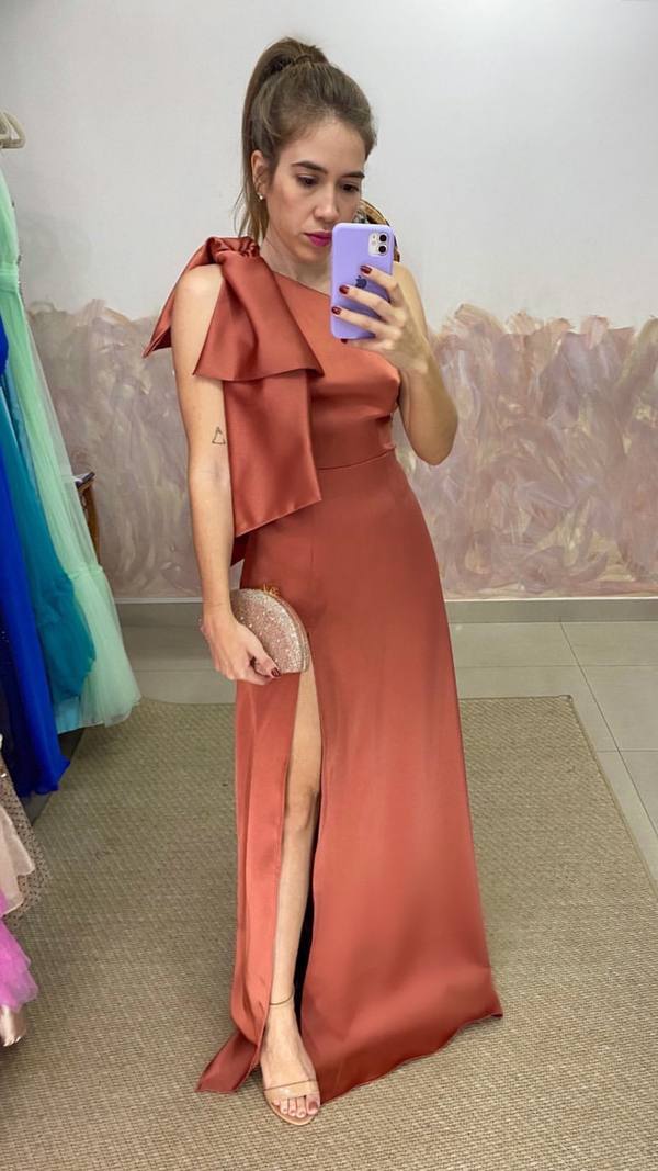 Vestido longo terracota de cetim, modelo um ombro com laço no ombro e saia com fenda.