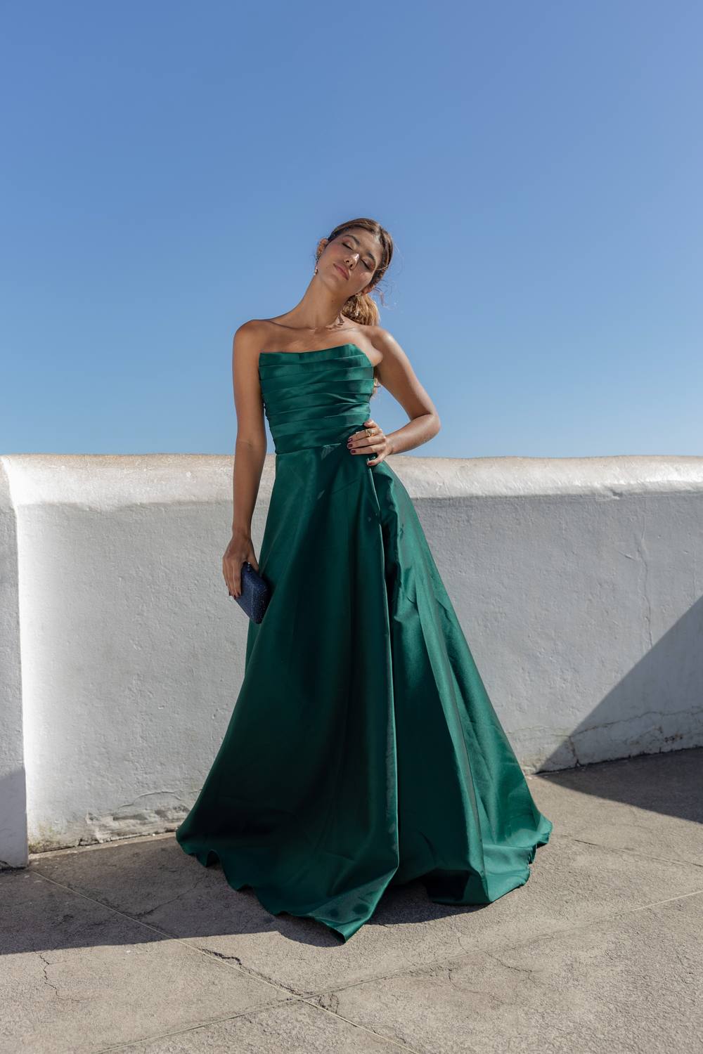 Vestido longo verde de tecido encorpado, decote tomara que caia, busto drapeado e saia ampla evasê.