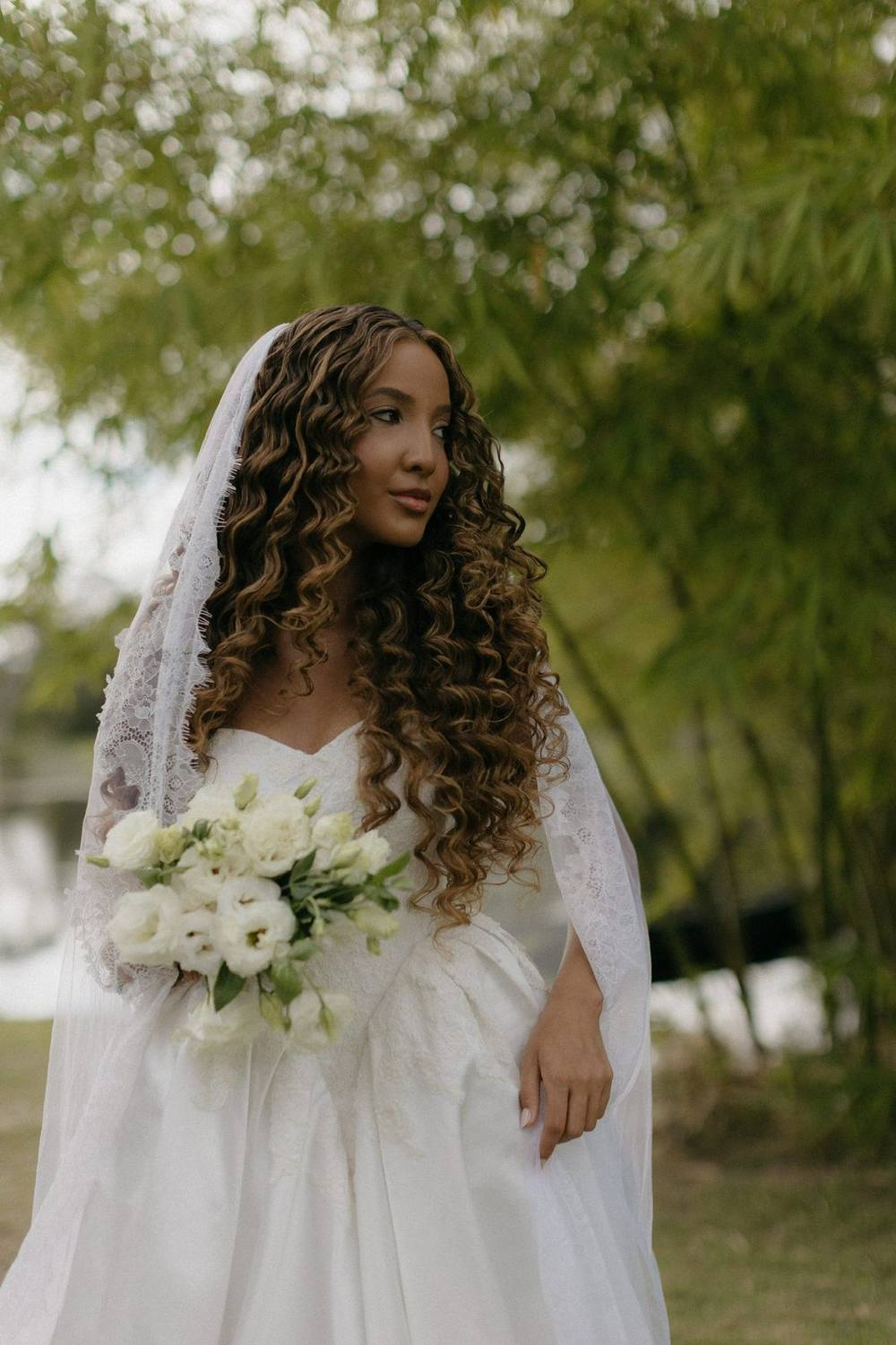Vestido de noiva branco evasê com véu e buquê, na igreja